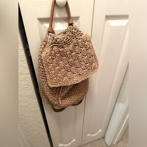 Tan woven small backpack.